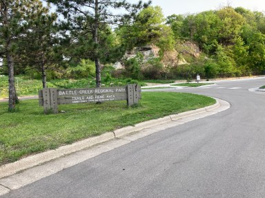 street in front of green space with sign saying Battle Creek Regional Park